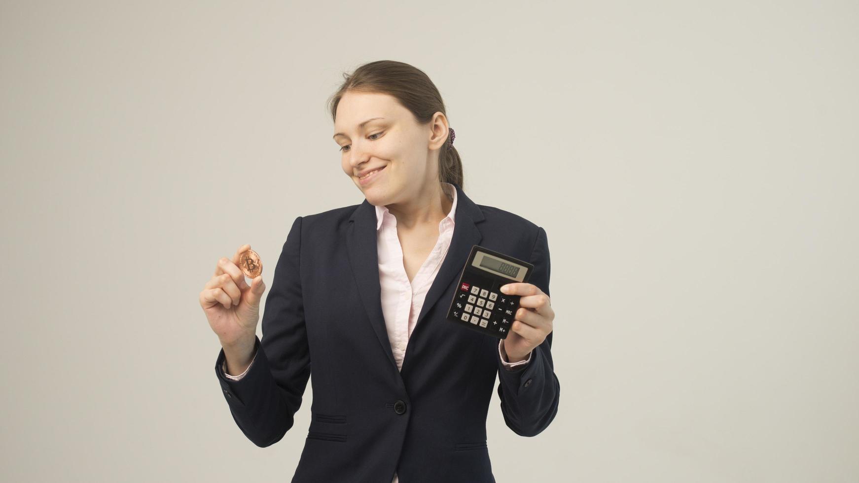 mujer sosteniendo una criptomoneda bitcoin física en la mano foto