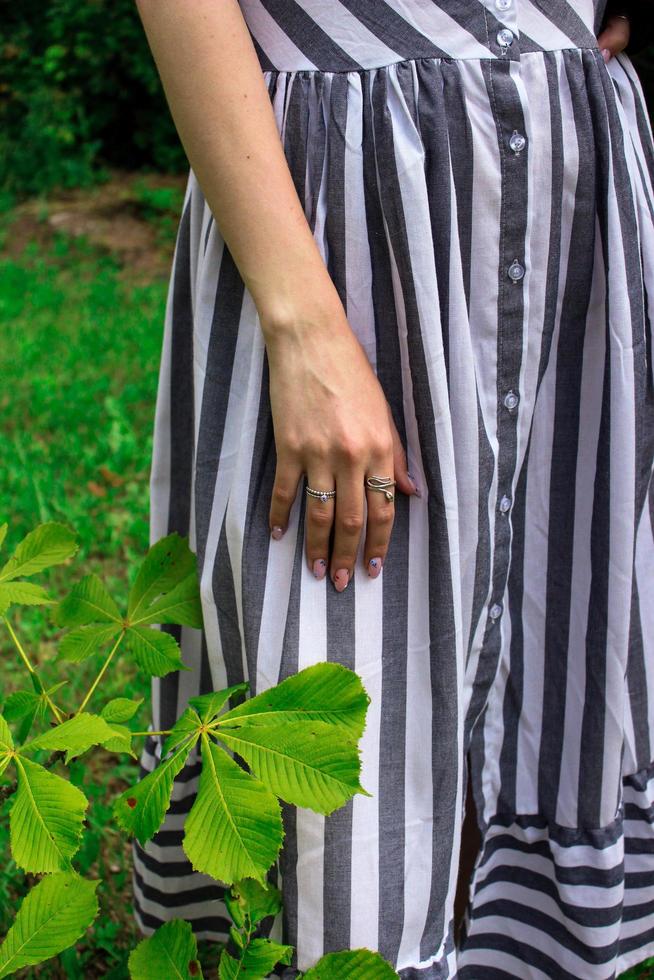 Girl's hand with rings in a striped dress photo