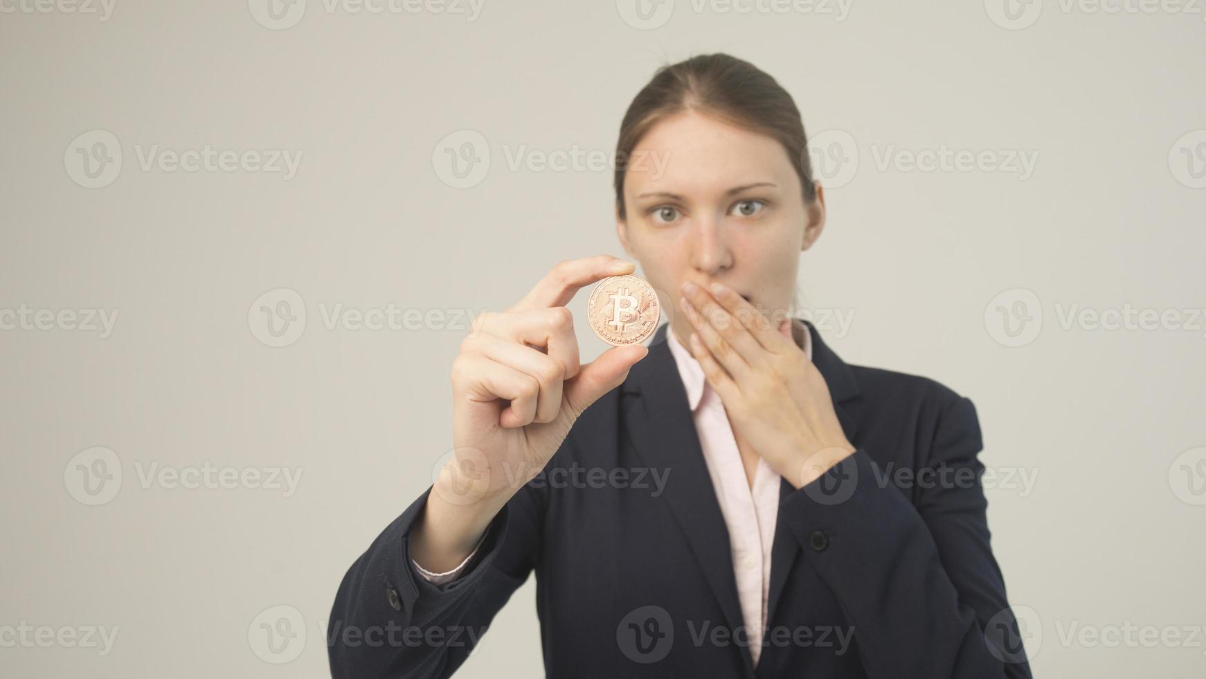 Woman holding a physical bitcoin cryptocurrency in her hand photo