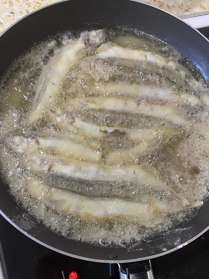 Frying small fish in a large amount of vegetable oil photo