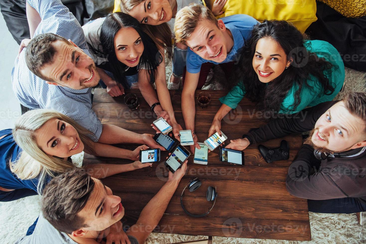 Top view hands circle using phone in cafe - Multiracial friends mobile addicted interior scene from above - Wifi connected people in bar table meeting - Concept of teamwork photo