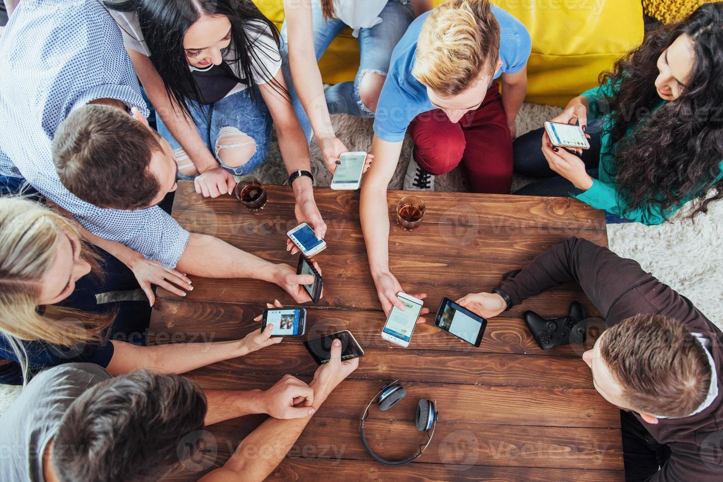 Top view hands circle using phone in cafe - Multiracial friends mobile addicted interior scene from above - Wifi connected people in bar table meeting - Concept of teamwork photo