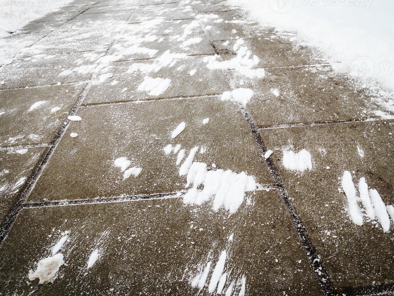 Wind made snow stains on tiled dark pavement surface 6071309 Stock