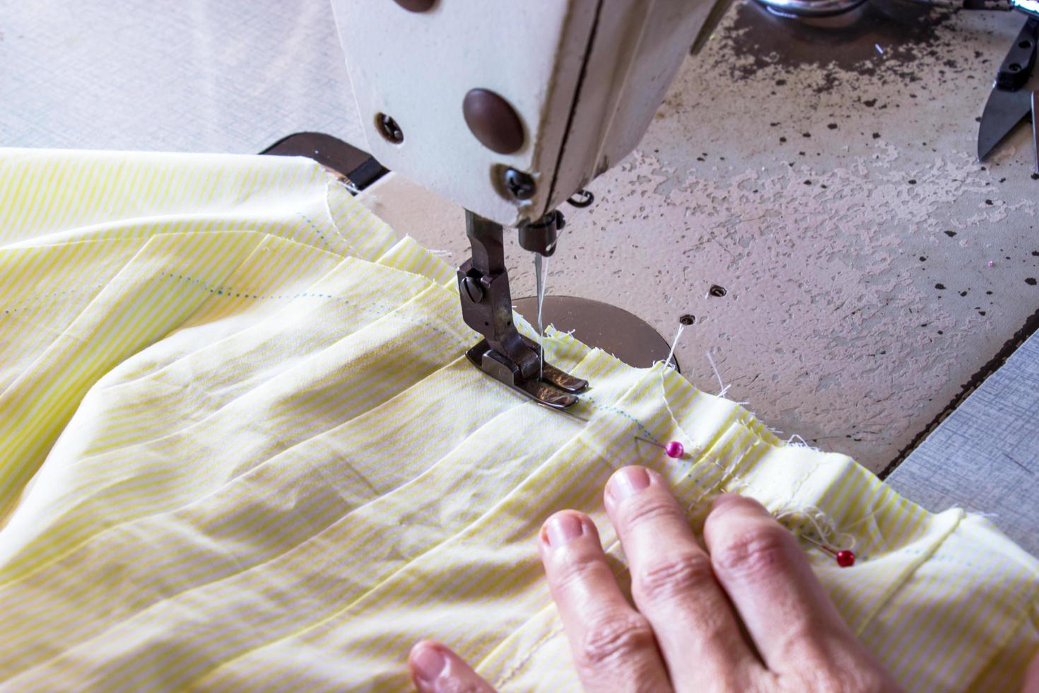 Imagen de las manos de las mujeres de la costurera trabajando en la máquina de coser. foto