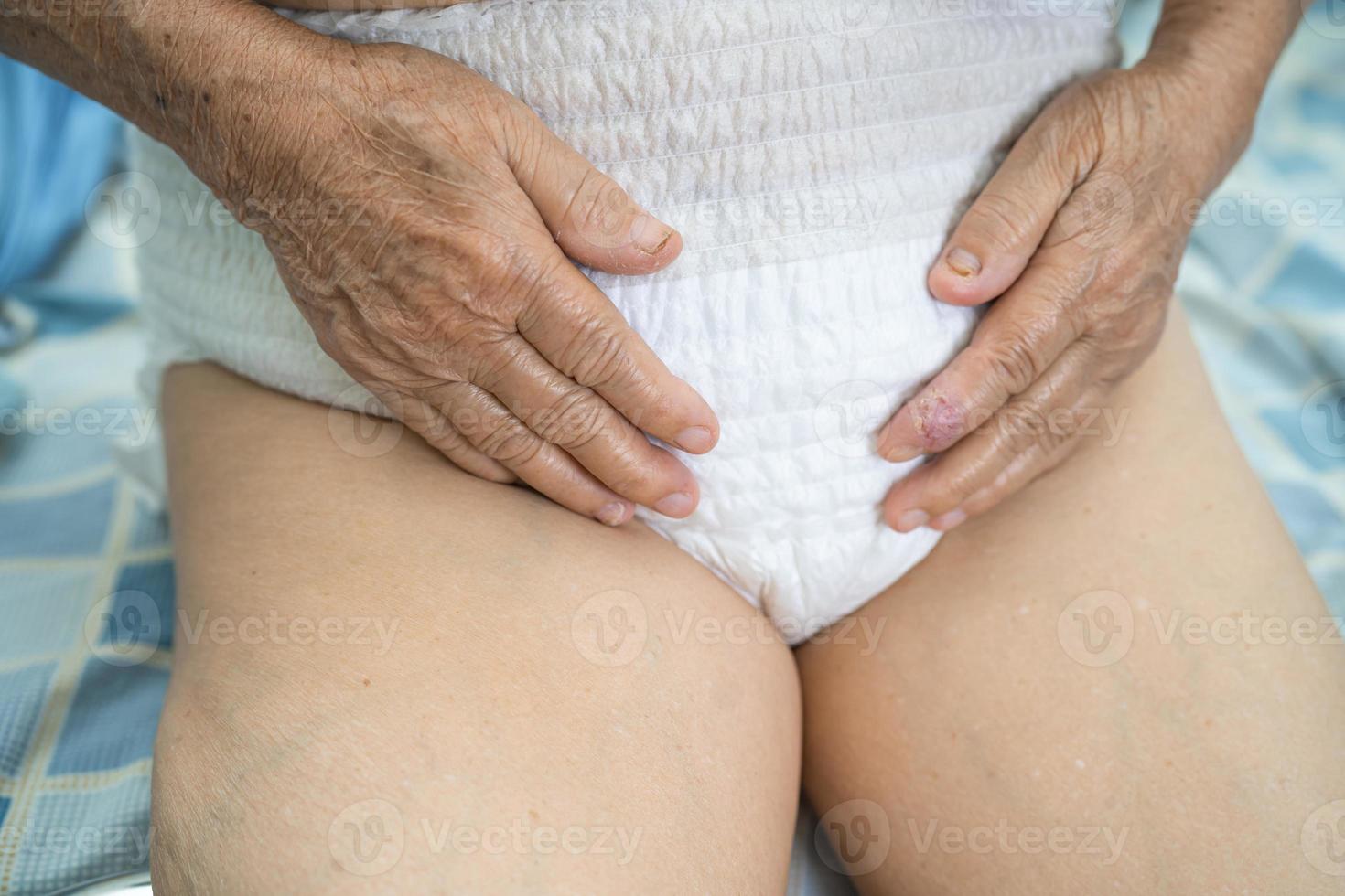 Paciente asiático mayor o mayor de la mujer de la señora mayor que lleva el pañal de la incontinencia en la sala del hospital de enfermería, concepto médico fuerte sano. foto