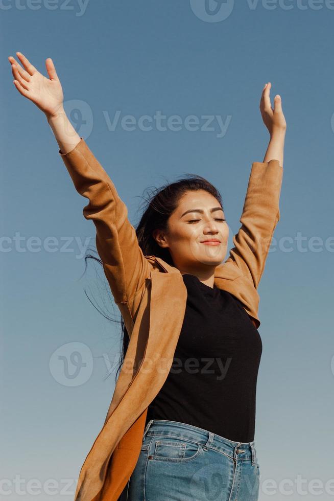woman raises her hands as a sign of freedom and happiness photo