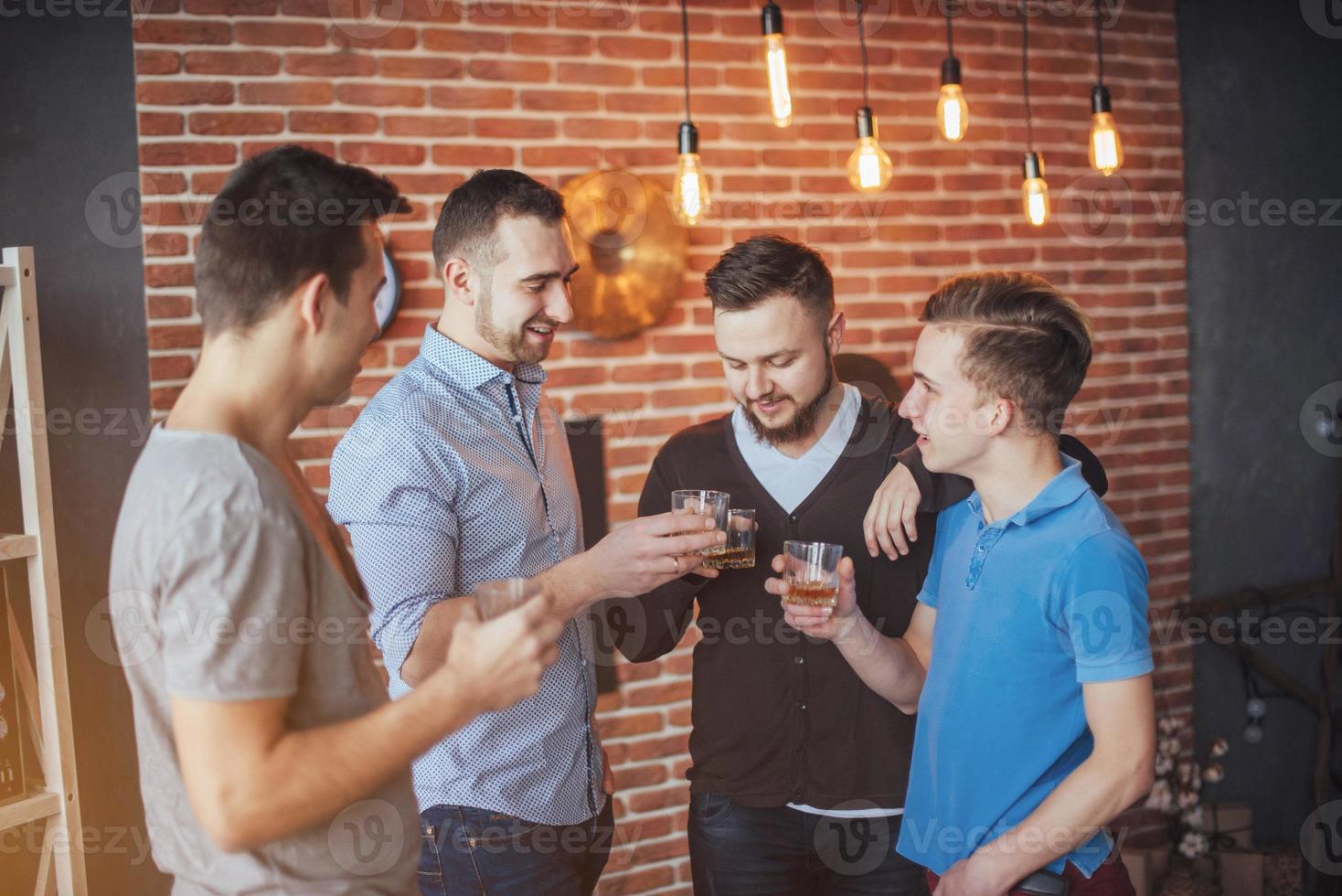 Cheerful old friends communicate with each other  glasses of whiskey in pub. Concept  entertainment and lifestyle photo