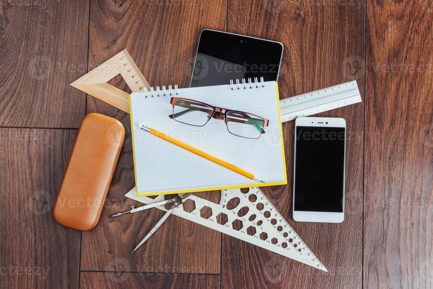 Top view of notebook, stationery, drawing tools and a few glasses. improvise. photo