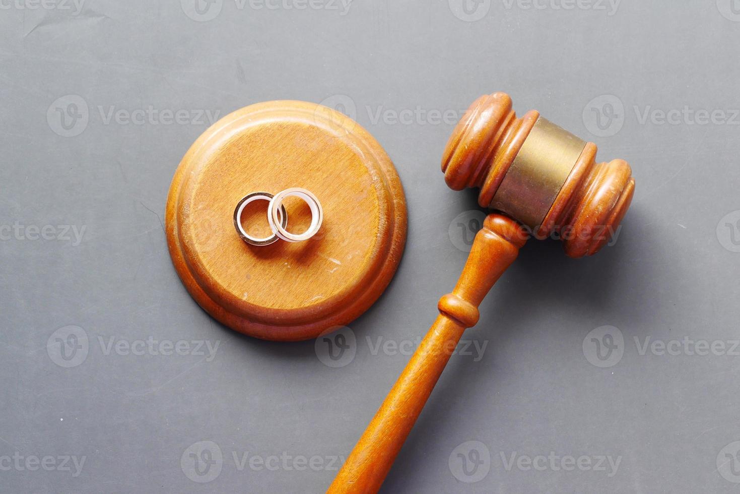 Divorce concept with gavel and wedding rings on table. photo