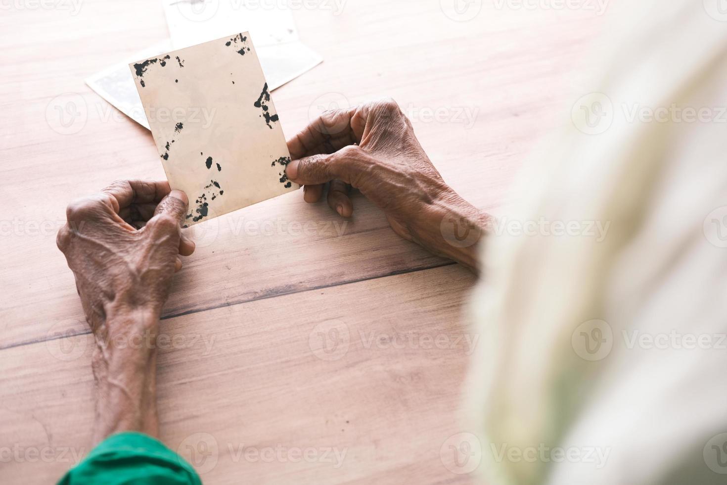 rear view of senior women holding old photograph photo