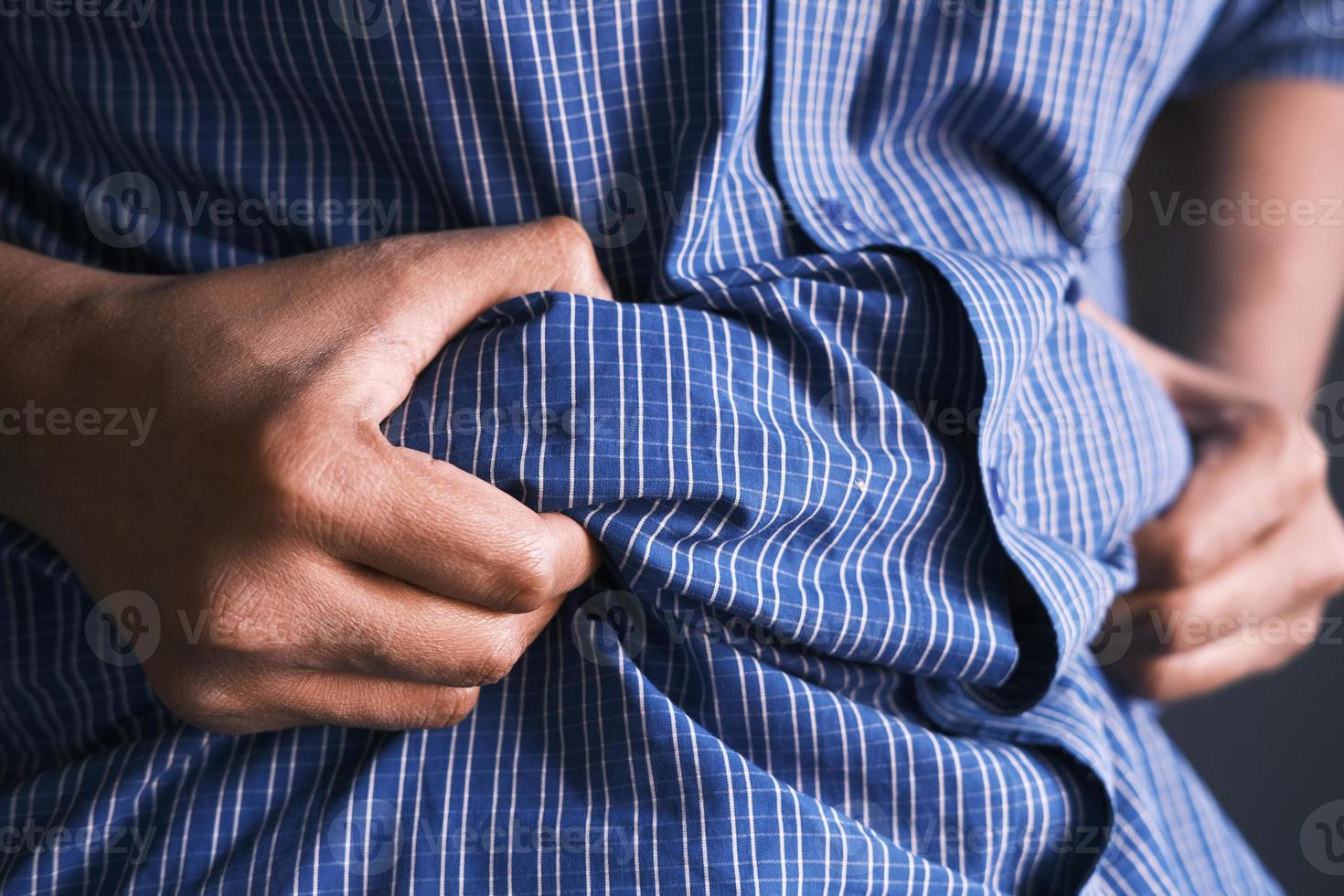 La mano del hombre sujetando el exceso de grasa abdominal, concepto de sobrepeso foto