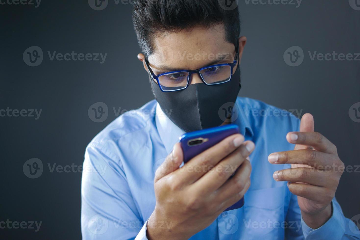 sick man in surgical face mask using smart phone, selective focus photo