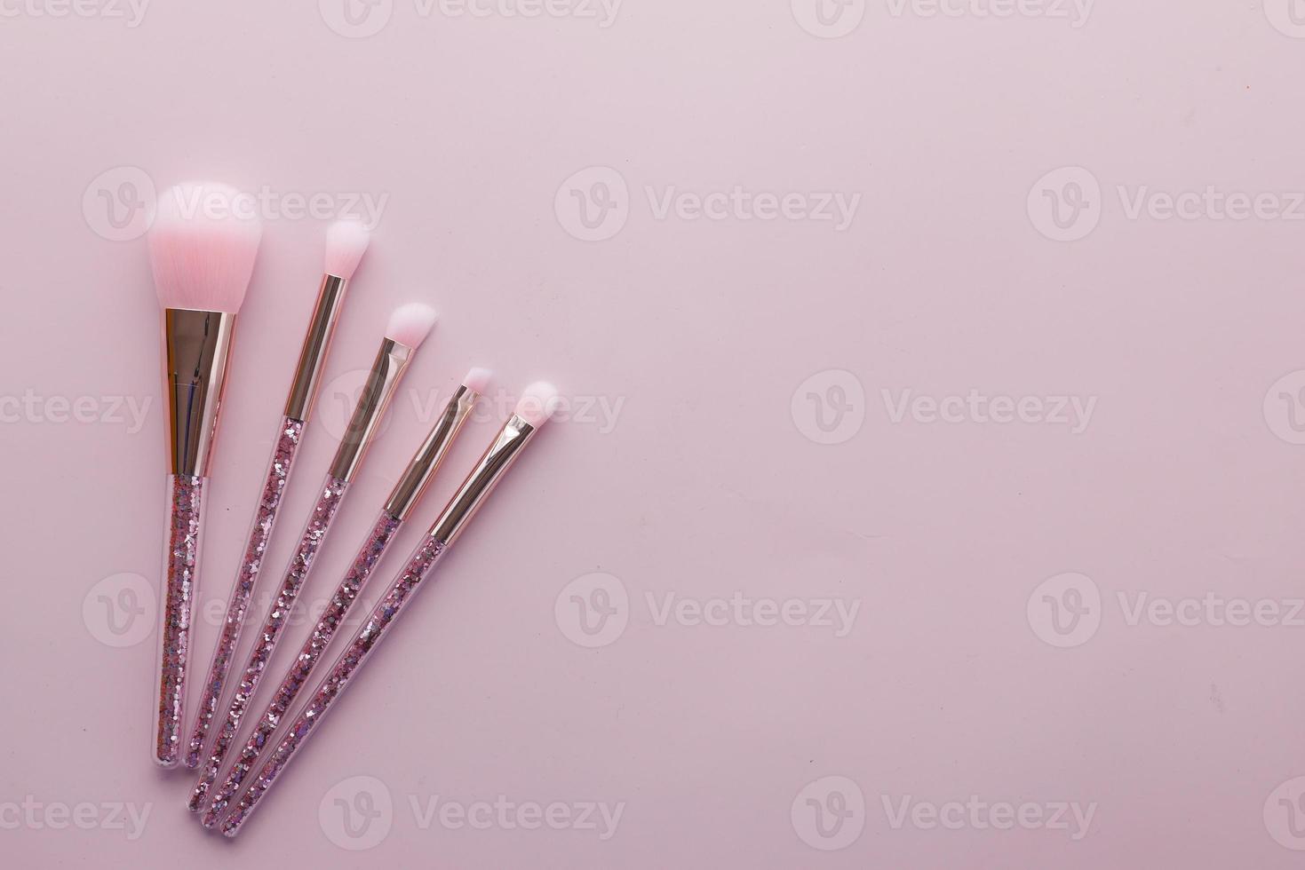 many makeup brush on pink background photo