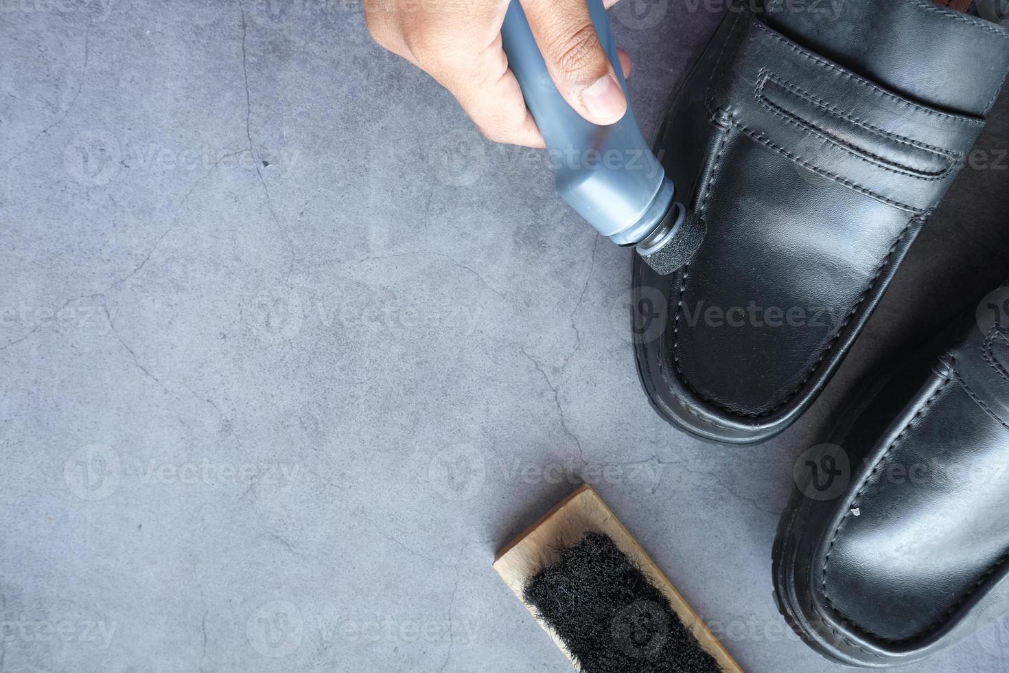 cleaning Shoe with a brush on floor photo