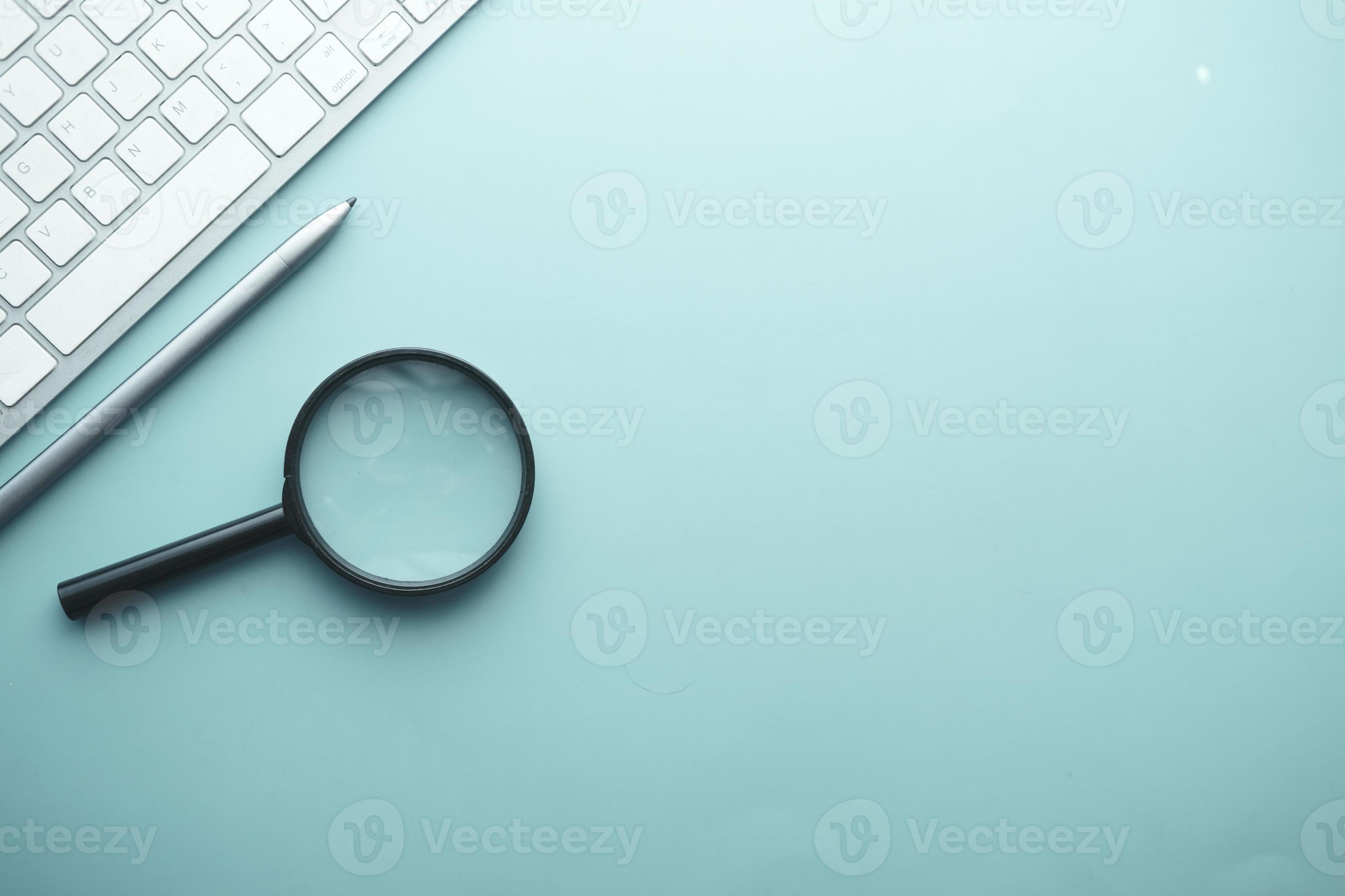 magnifying glass, pen and keyboard on blue background 6072845 Stock