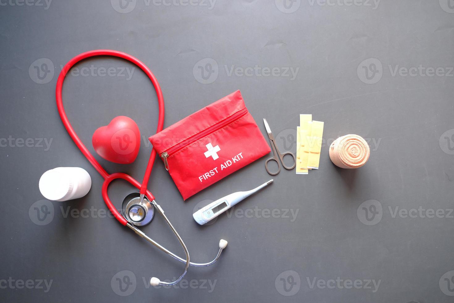 top view of first aid kit and stethoscope on black background photo