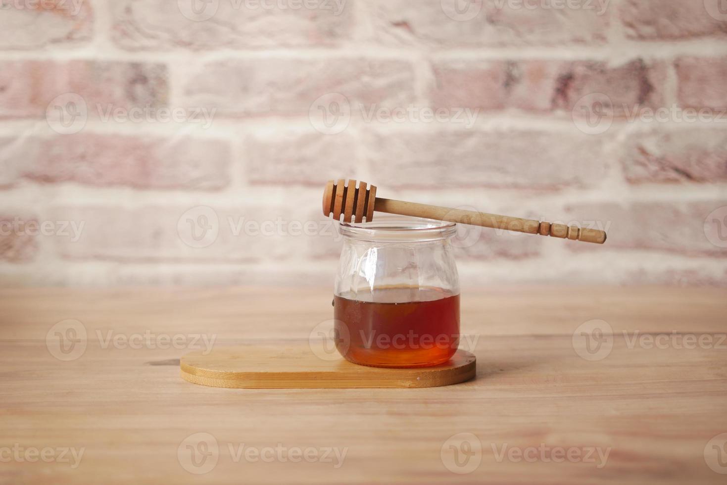Cerca de miel fresca con una cuchara en la mesa foto