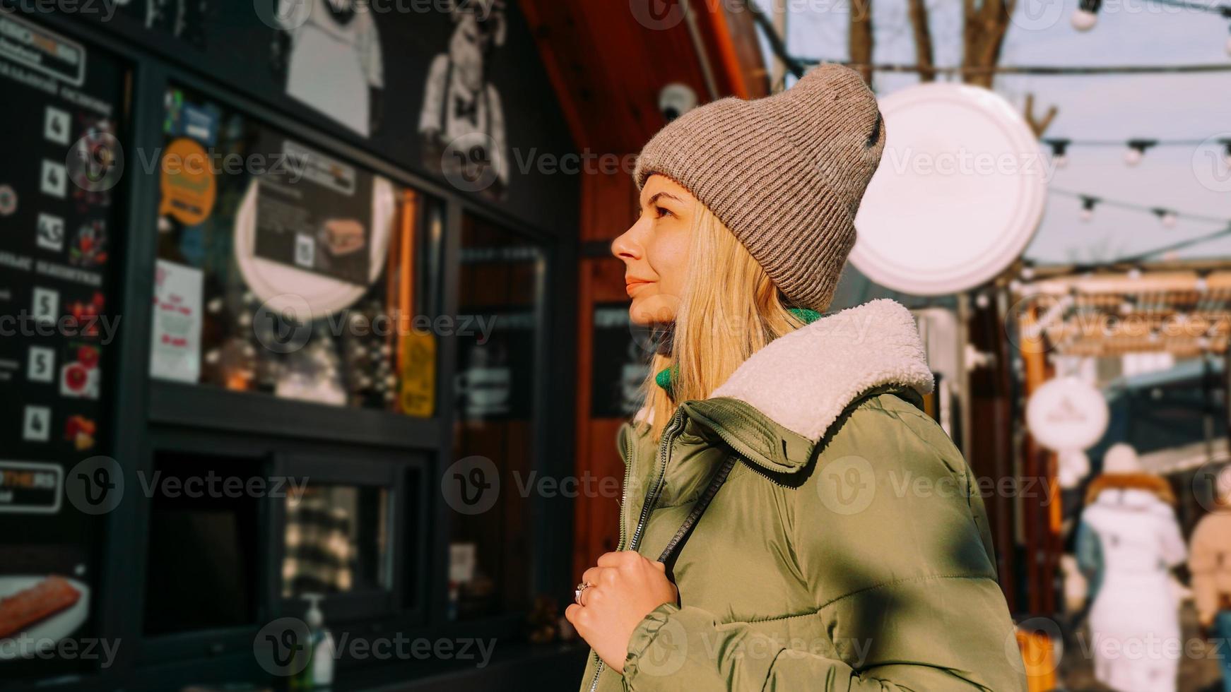 Woman at an urban street food court chooses food from a menu photo