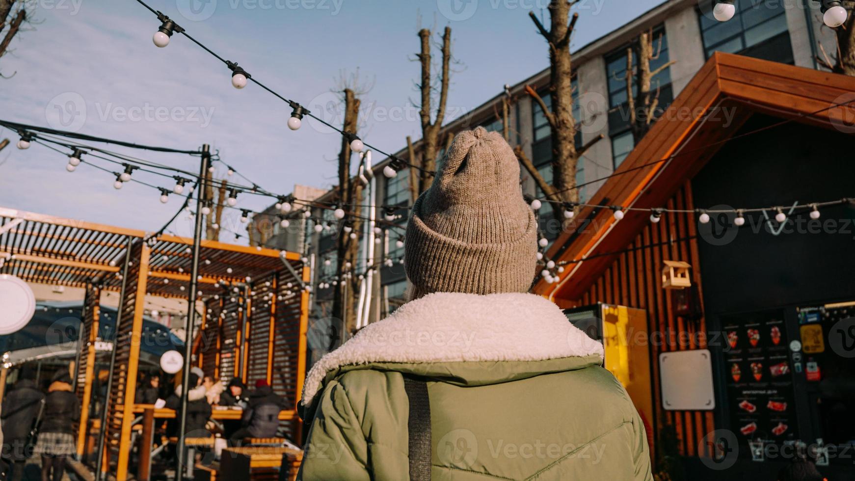 Young blonde at the European street food fair. View from the back. photo