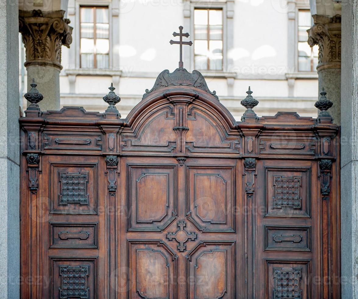 Ancient wooden carved door with crucifix photo