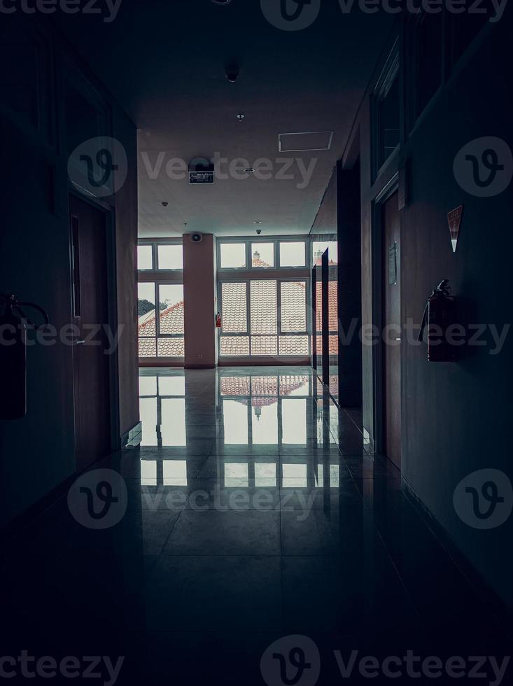 pasillo de oficina con un ambiente tenso y silencioso y de terror y nadie. efecto oscuro ventanas y vidrios. foto