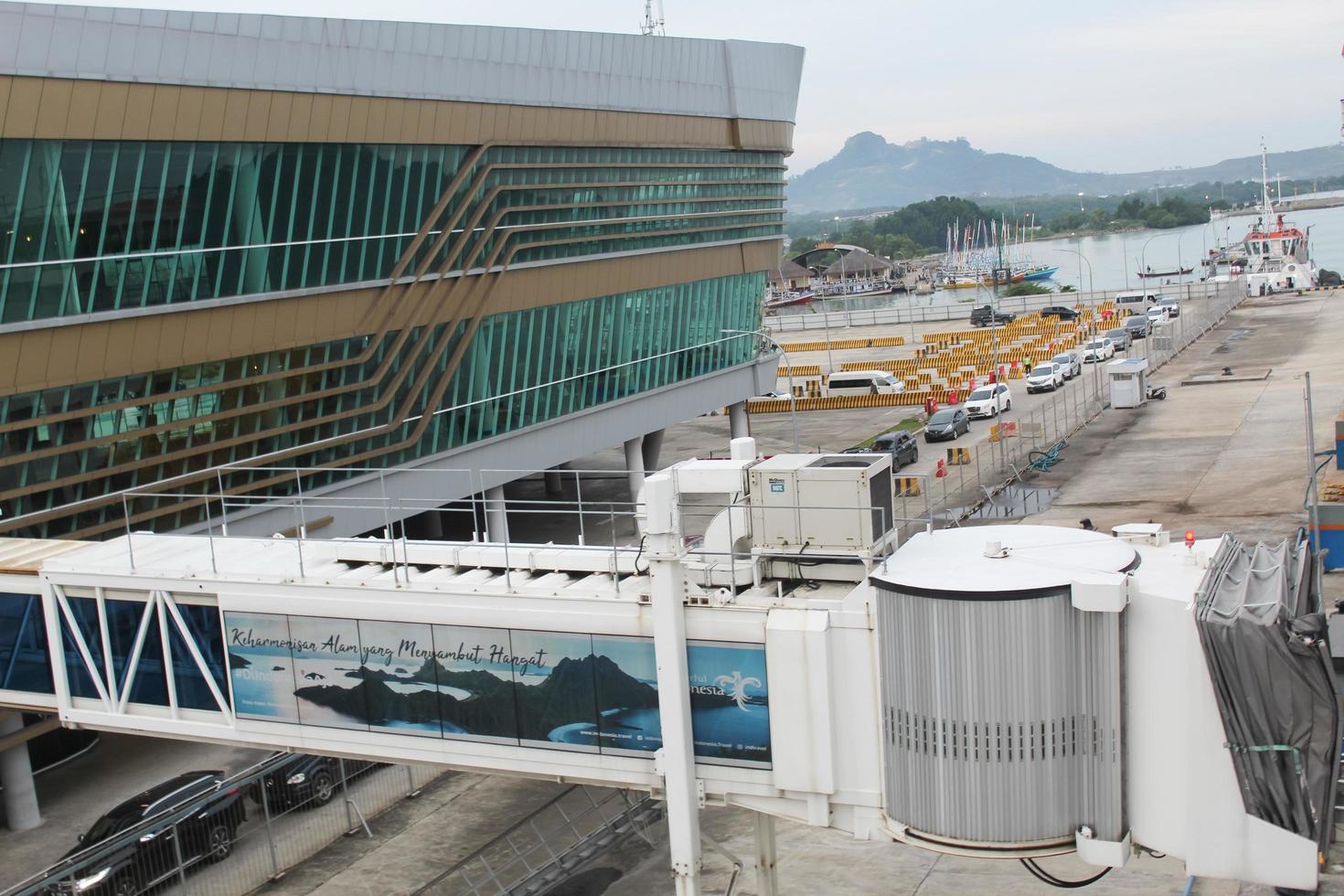 building at the Bakauheni express pier and a queue of cars can be seen boarding the ship. Bakauheni, Lampung, Sumatra - Indonesia, 2022 photo