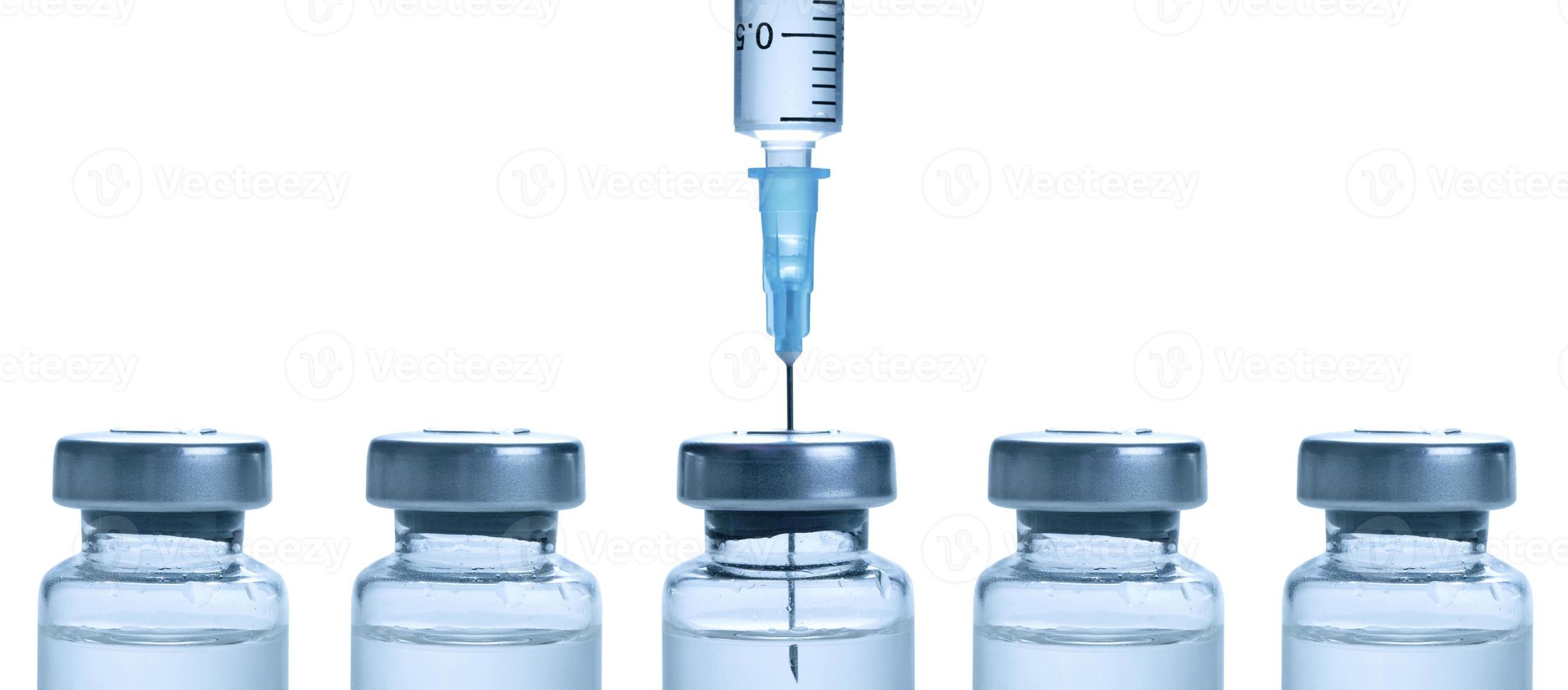 Medical syringe with a needle and a bollte with vaccine. photo