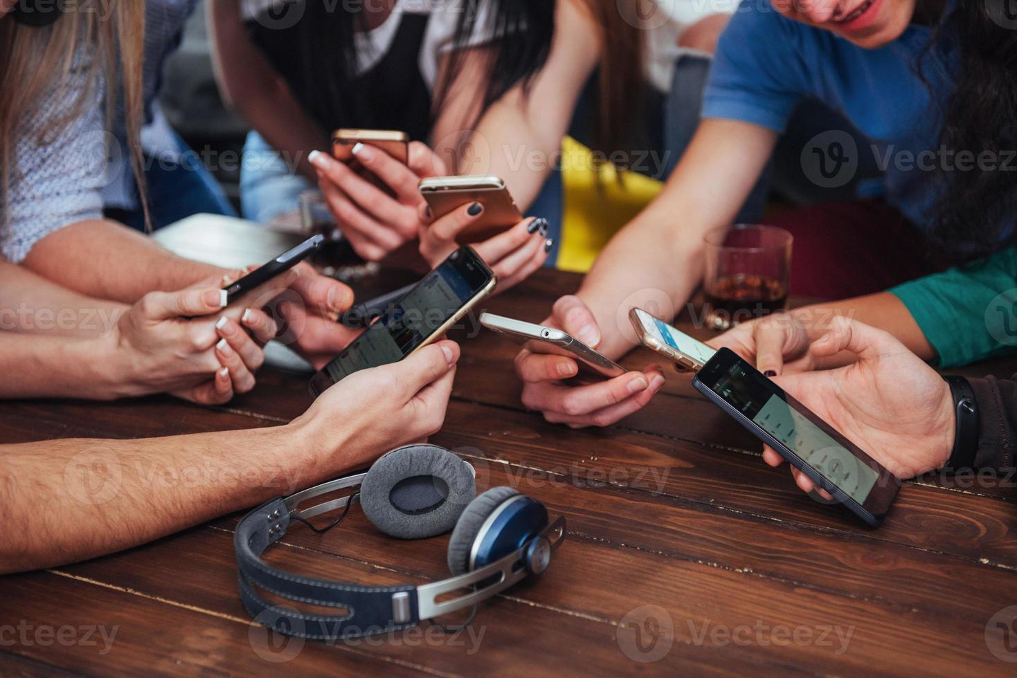 Top view hands circle using phone in cafe - Multiracial friends mobile addicted interior scene from above - Wifi connected people in bar table meeting - Concept of teamwork photo