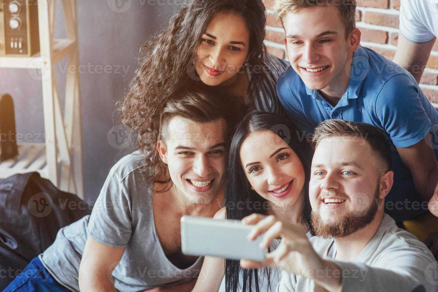 agrupar a hermosos jóvenes haciendo selfie en un café, mejores amigos niñas y niños juntos divirtiéndose, planteando un concepto de estilo de vida emocional foto