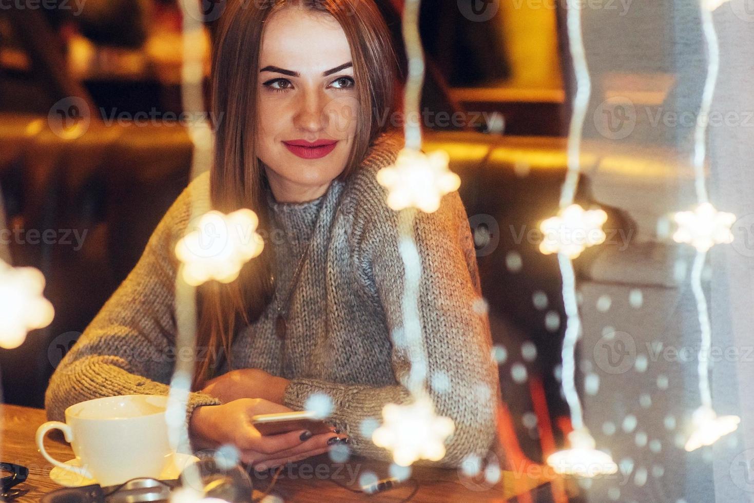 Young beautiful woman sitting in cafe, drinking coffee. Christmas, new year, Valentines day, winter holidays concept photo