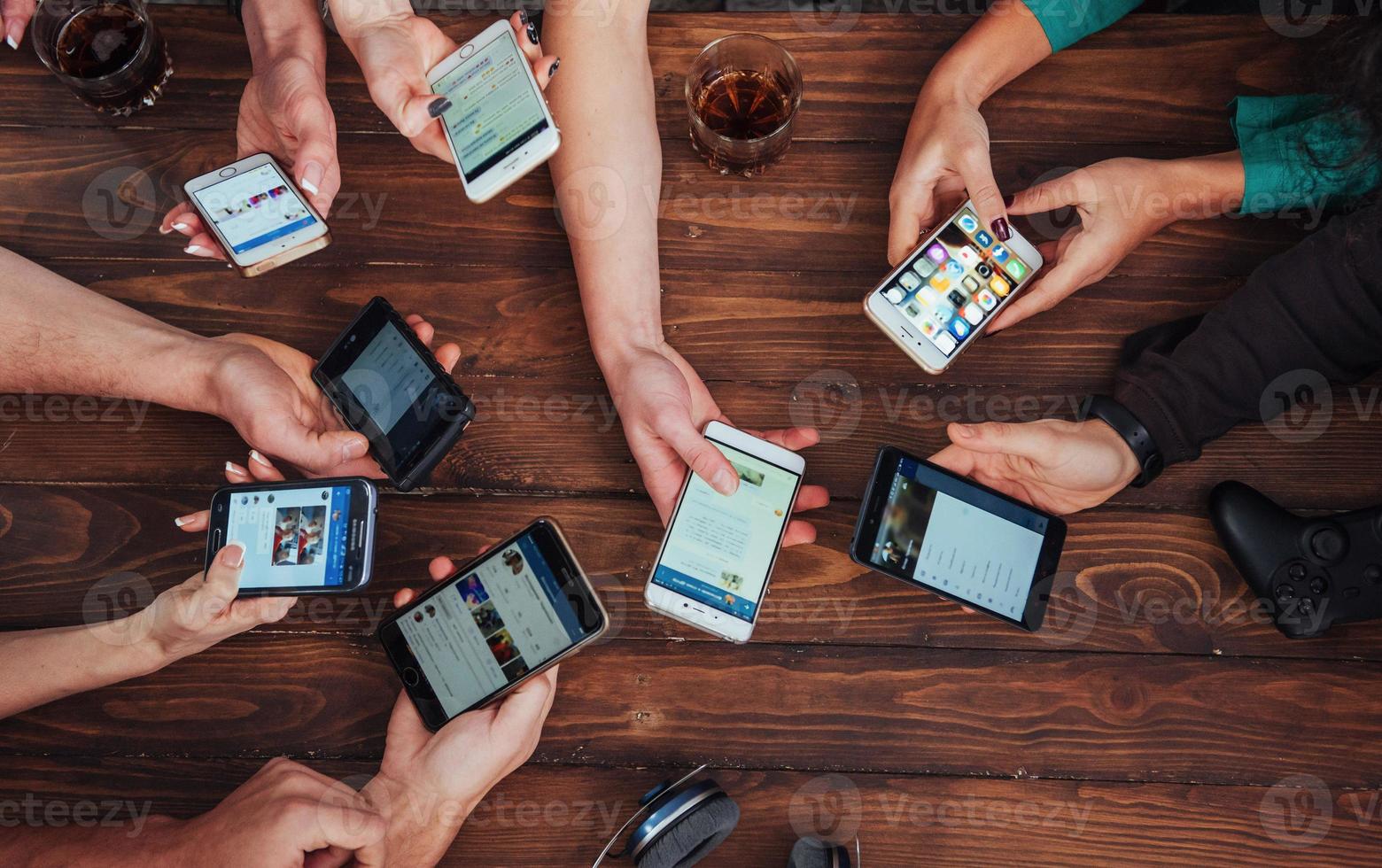 círculo de manos de vista superior usando el teléfono en el café - amigos multirraciales escena interior adicta al móvil desde arriba - personas conectadas wifi en la reunión de la mesa del bar - concepto de trabajo en equipo foto