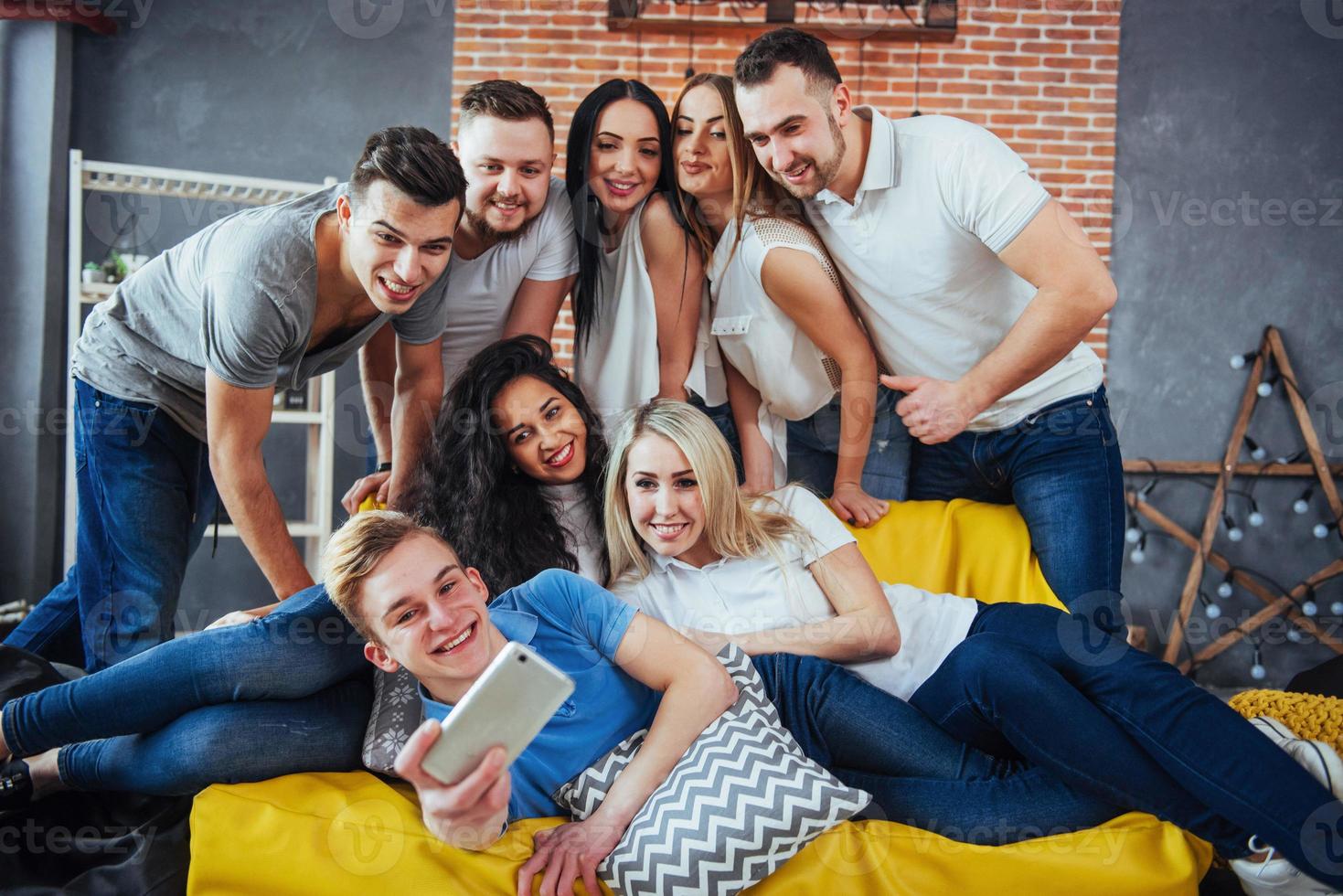 agrupar a hermosos jóvenes haciendo selfie en un café, mejores amigos niñas y niños juntos divirtiéndose, planteando un concepto de estilo de vida emocional foto