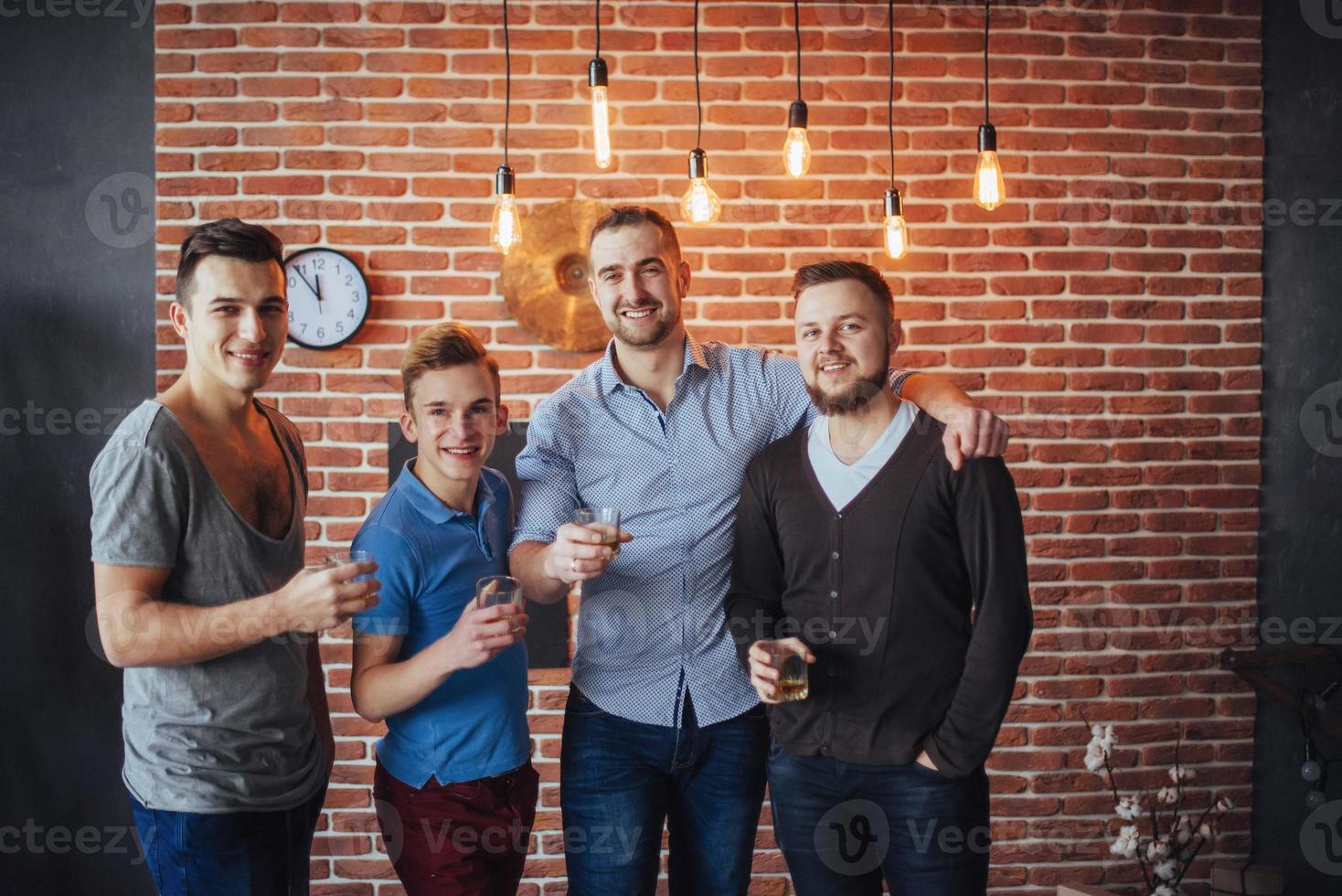 viejos amigos alegres se comunican entre sí con vasos de whisky en el pub. concepto de entretenimiento y estilo de vida foto