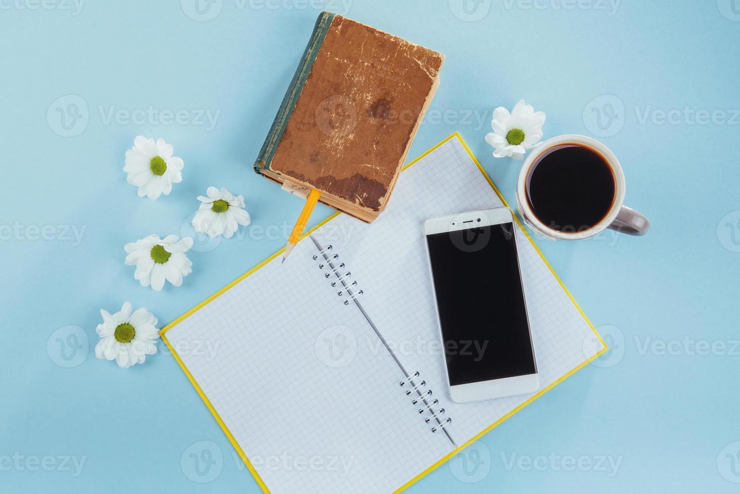 On the blue background notebook pencil, ruler and white flowers photo