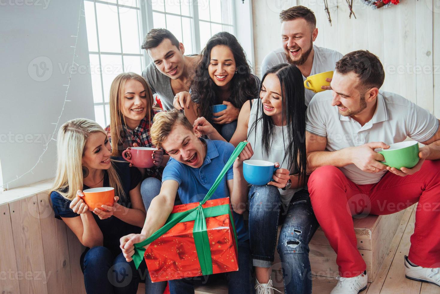 Group of best friends at party. smiling and cheerful people sitting on the stairs  a cup  coffee  greet the birthday,  great gift photo