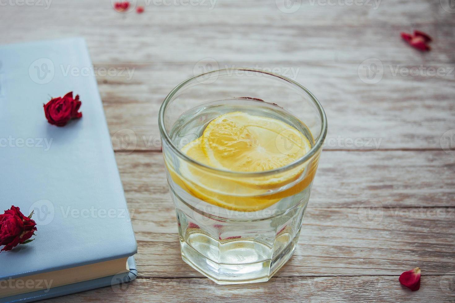 book glasses and flower petals  glass of water with lemon. photo