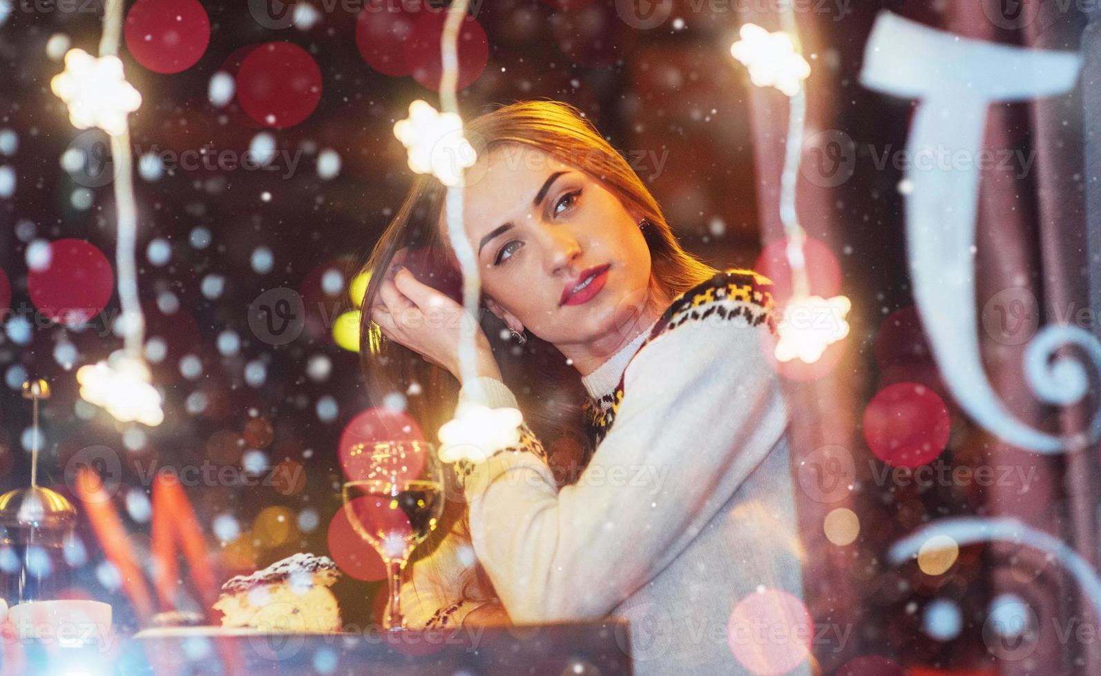 Young beautiful woman sitting in cafe, drinking wine. Christmas, new year, Valentines day, winter holidays concept photo