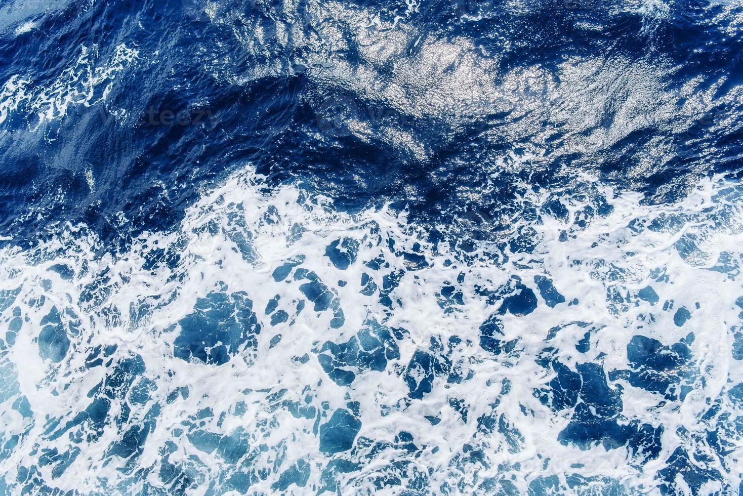 océano atlántico con agua azul en un día soleado. olas, espuma y w foto