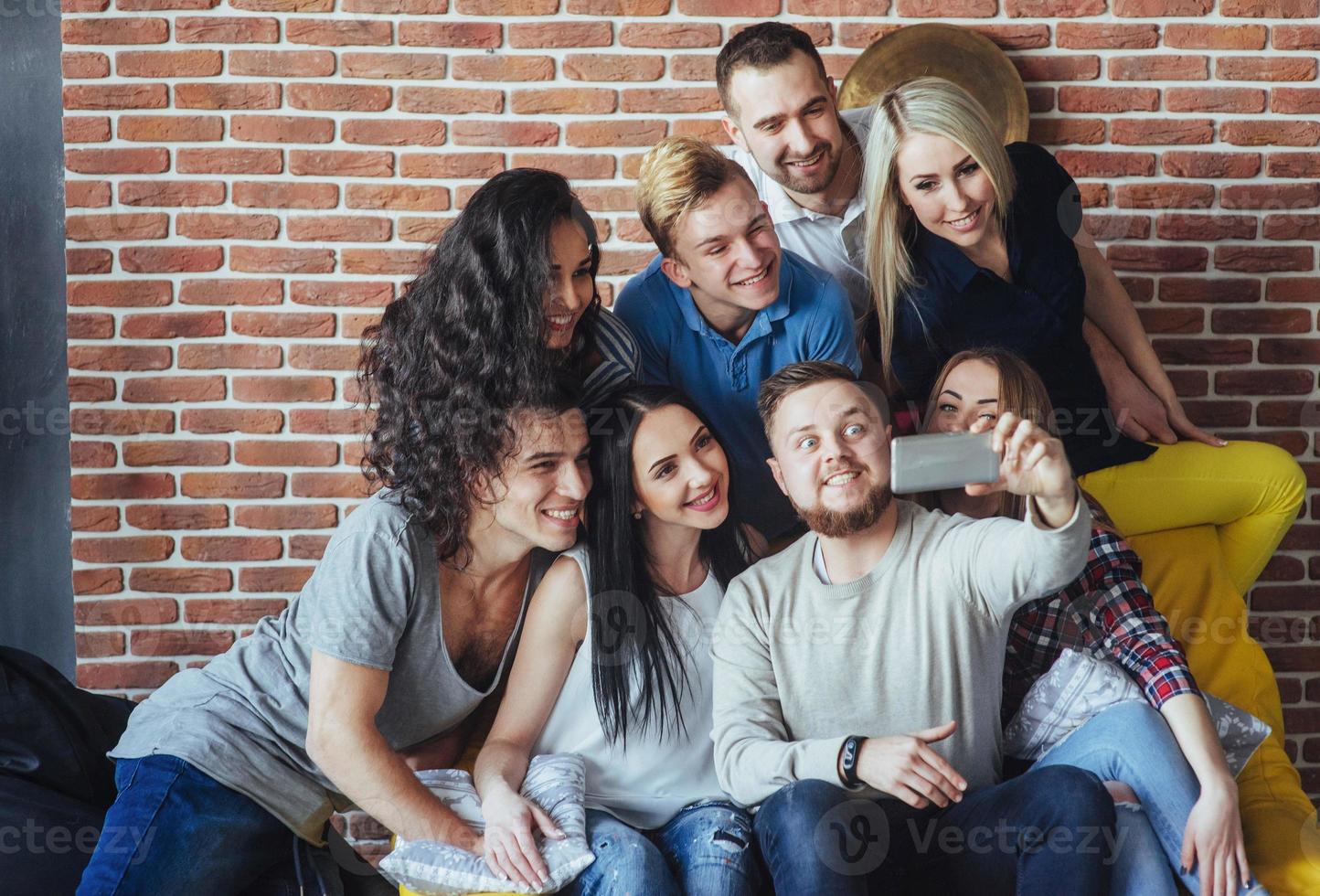 agrupar a hermosos jóvenes haciendo selfie en un café, mejores amigos niñas y niños juntos divirtiéndose, planteando un concepto de estilo de vida emocional foto