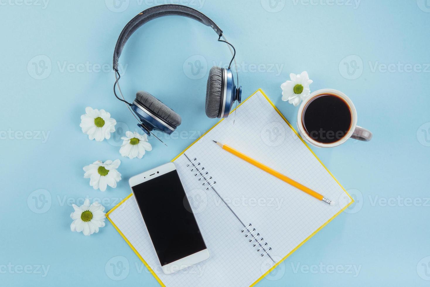 On the blue background notebook pencil, ruler and white flowers photo