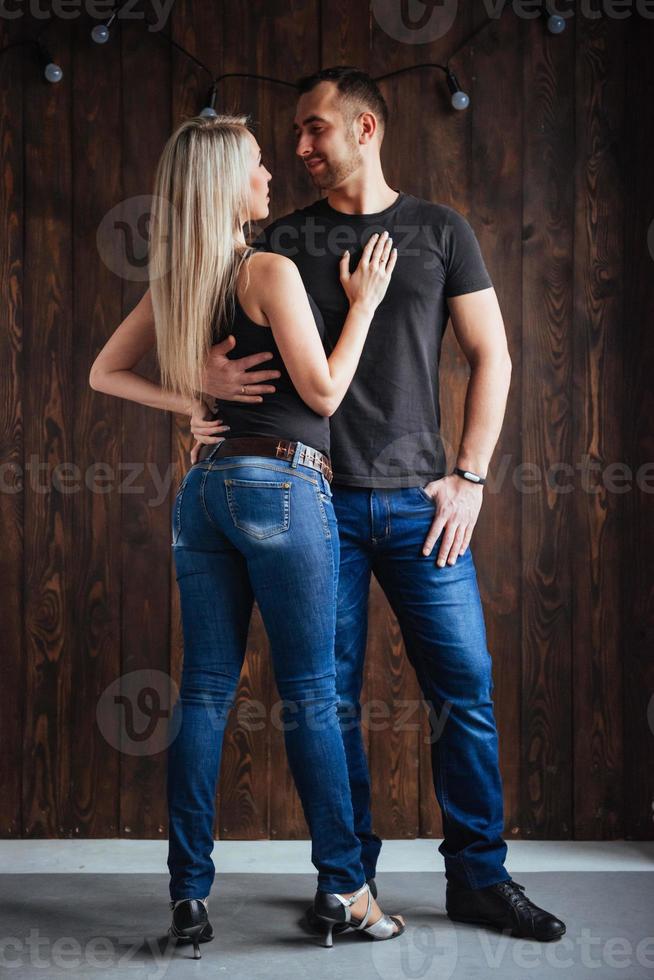 Young couple dancing latin music Bachata, merengue, salsa. Two elegance pose on cafe with brick walls photo