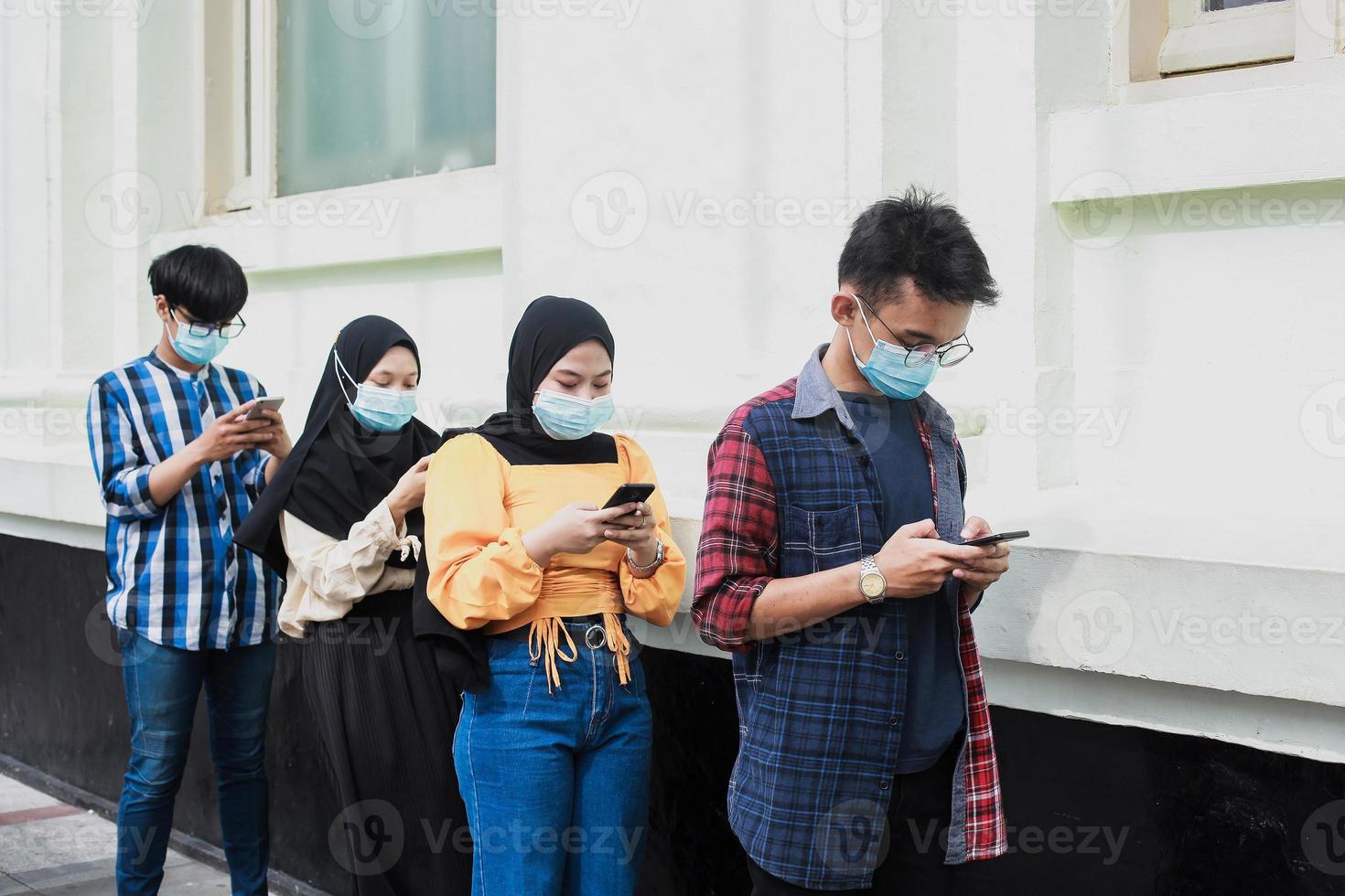 Group of young people in a row keeping social distancing against the diffusion of the coronavirus or covid-19 pandemic disease. New normal concept photo