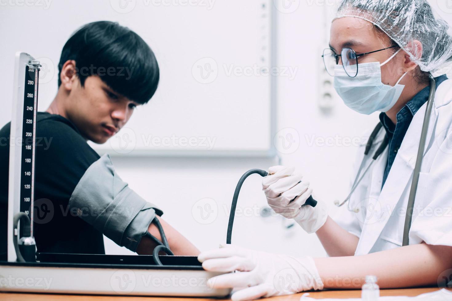 Female doctor examining guy patient measuring high low arterial blood pressure using medical tonometer at hospital. photo