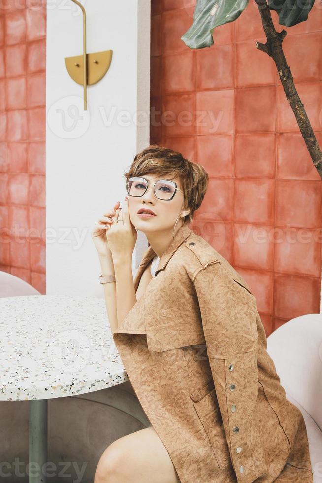 Pretty asian woman blonde posing with a brown coat photo