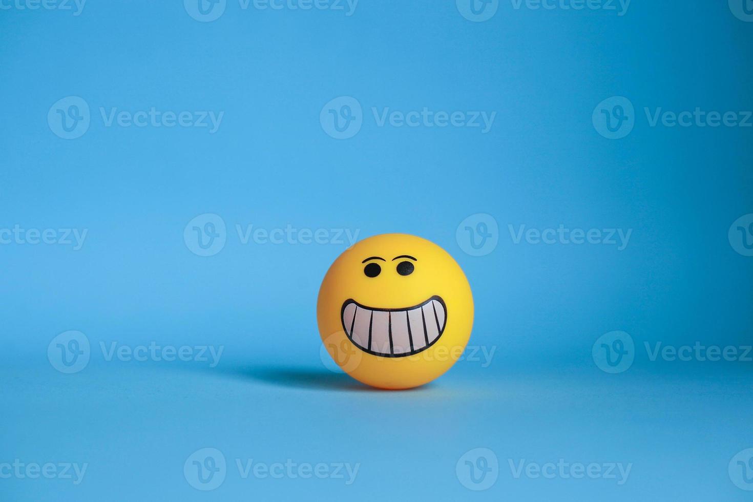 Smiley emoticon isolated on blue background photo