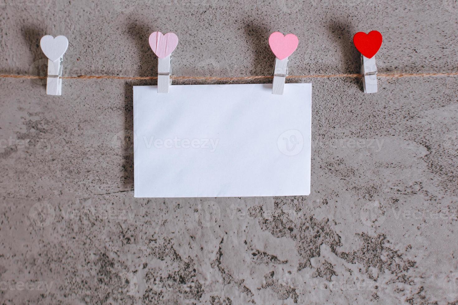 White envelope pinched on clothes line rope with mini heart shape photo