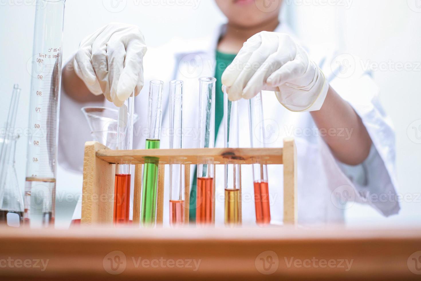 líquido colorido en el tubo de ensayo con la mano del estudiante. día nacional de la ciencia, día mundial de la ciencia foto