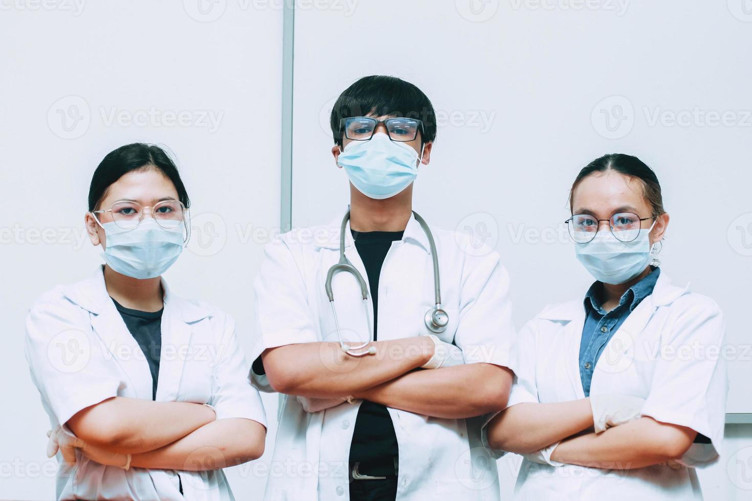 grupo de médicos con máscara protectora y uniforme posando con confianza foto