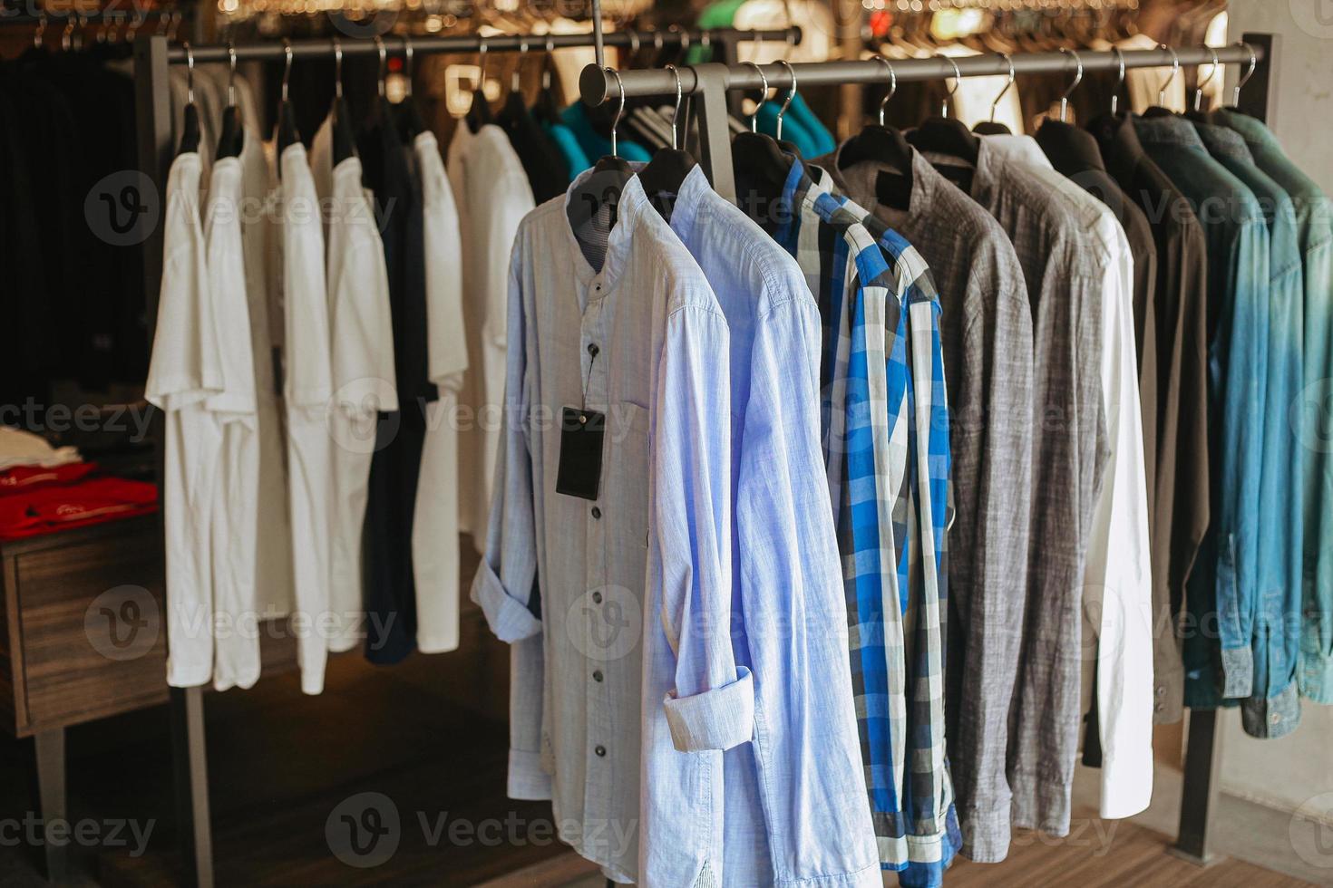 Various of shirt hanging on hanger clothes inside the store photo