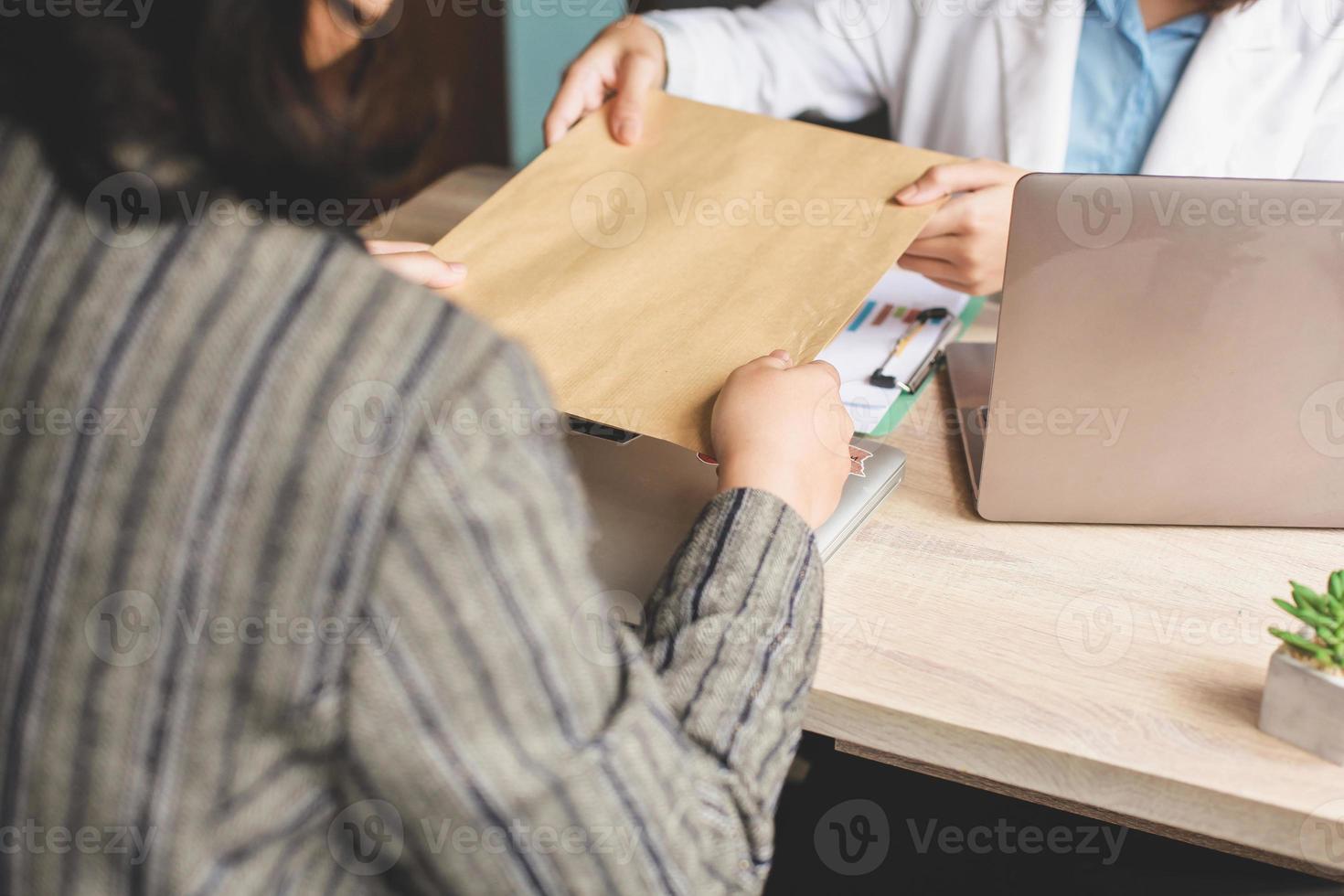 Cropped shot of business woman giving envelope to colleague. Promotion, HR concept, unemployment concept, searching for job, envelope with Job offer message photo